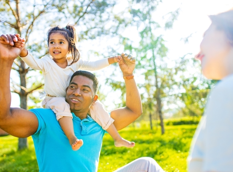 Father with young daughter on shoulders